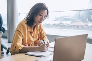 woman writing on her notebook
