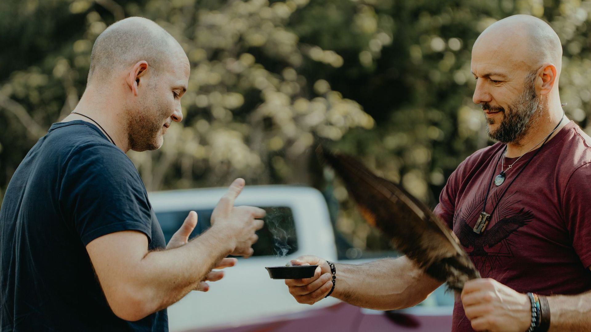 Kevin leading a smudging ceremony with another man