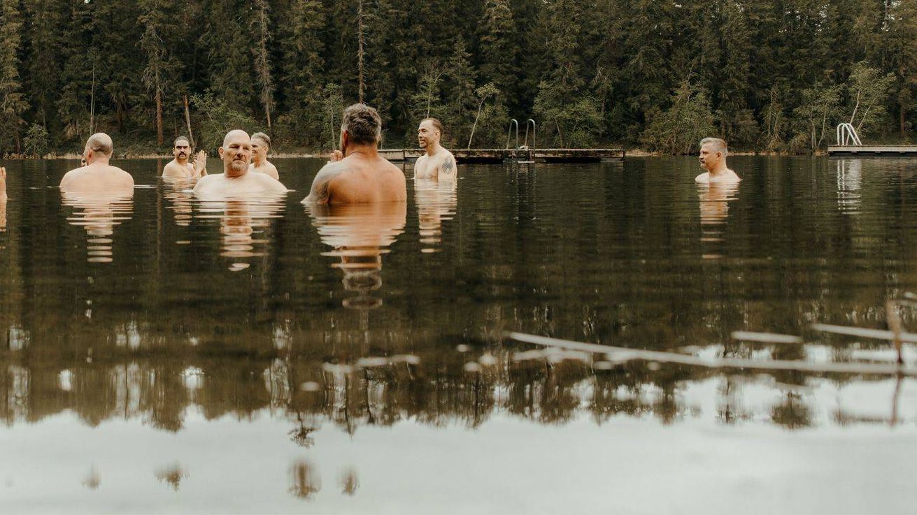 A group of men standing together in a lake