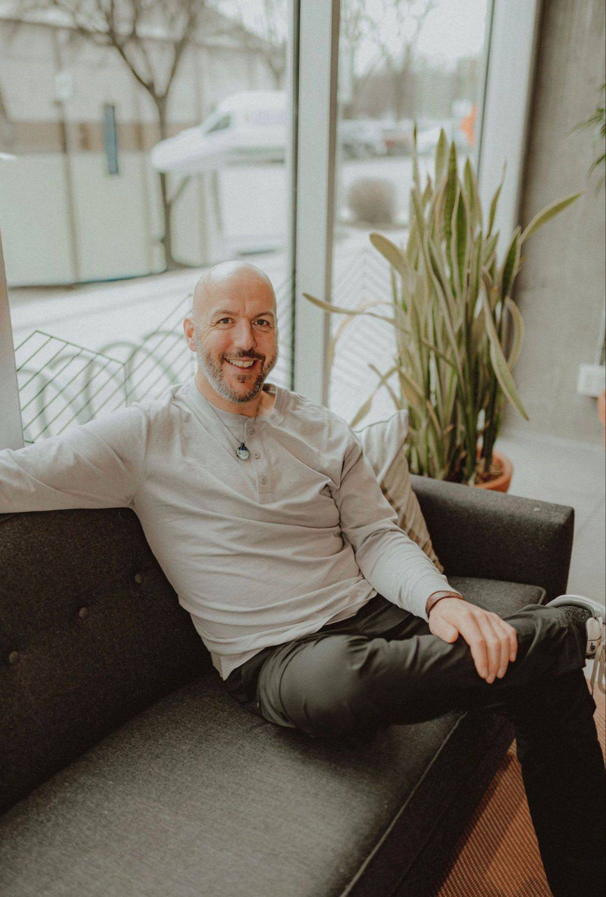 Kevin McNee seated on a sofa, smiling