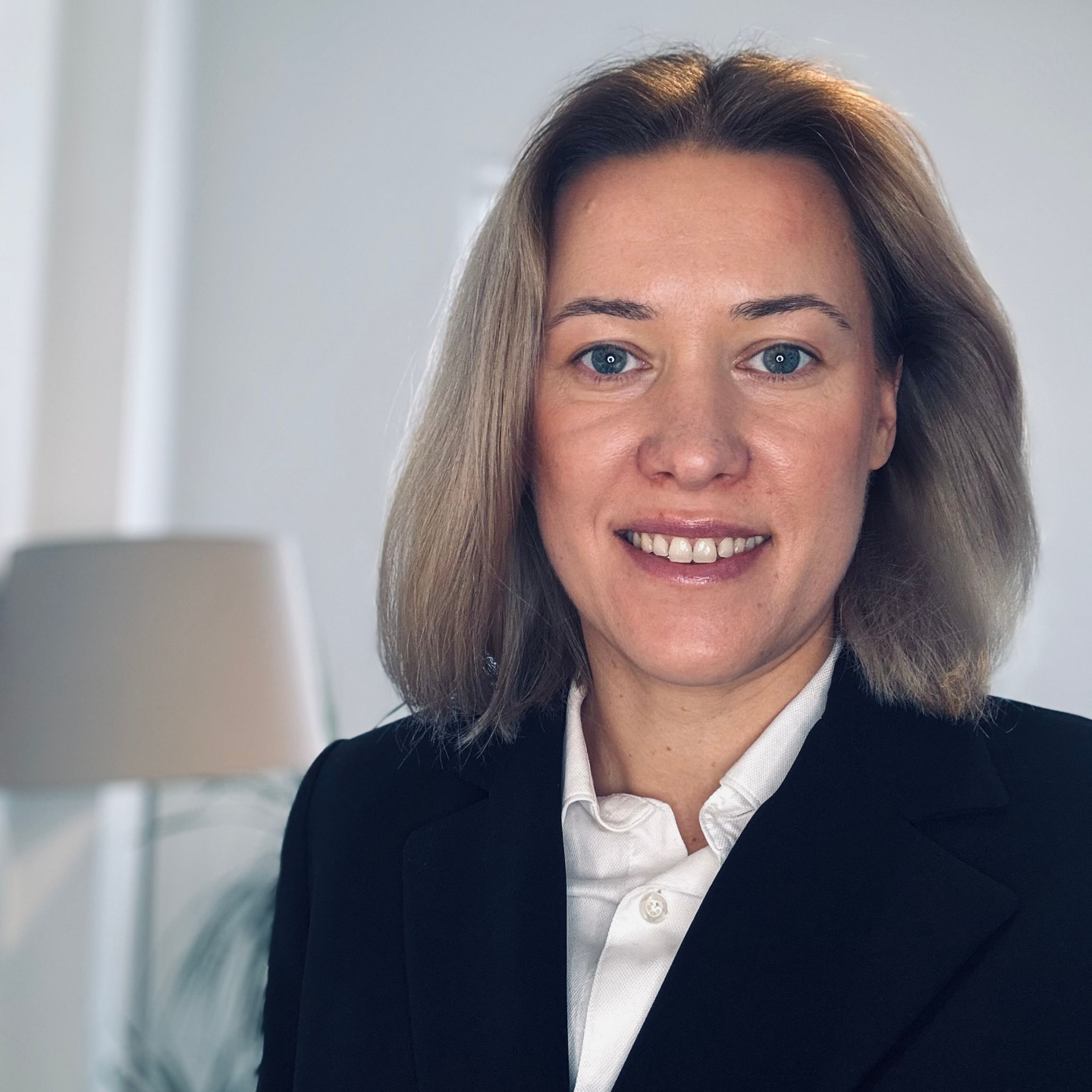 Headshot of smiling, welcoming 50s bald white gay cisgender white man with ginger-grey beard, pierced ears, and black shirt