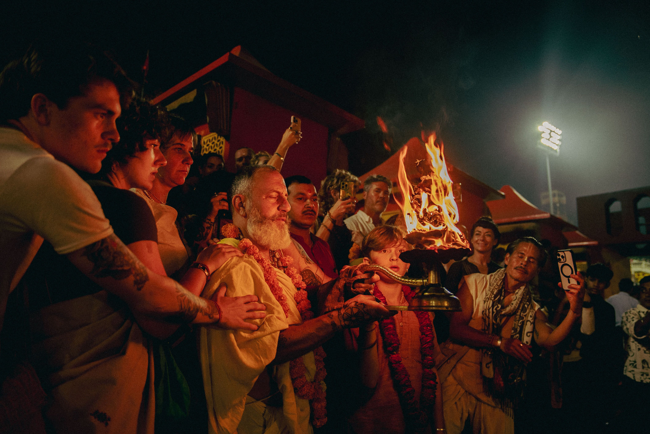 Devotees participate in Ganga Aarti at night, as a priest offers a flaming oil lamp during the sacred Hindu ceremony on the Ganges River in India.