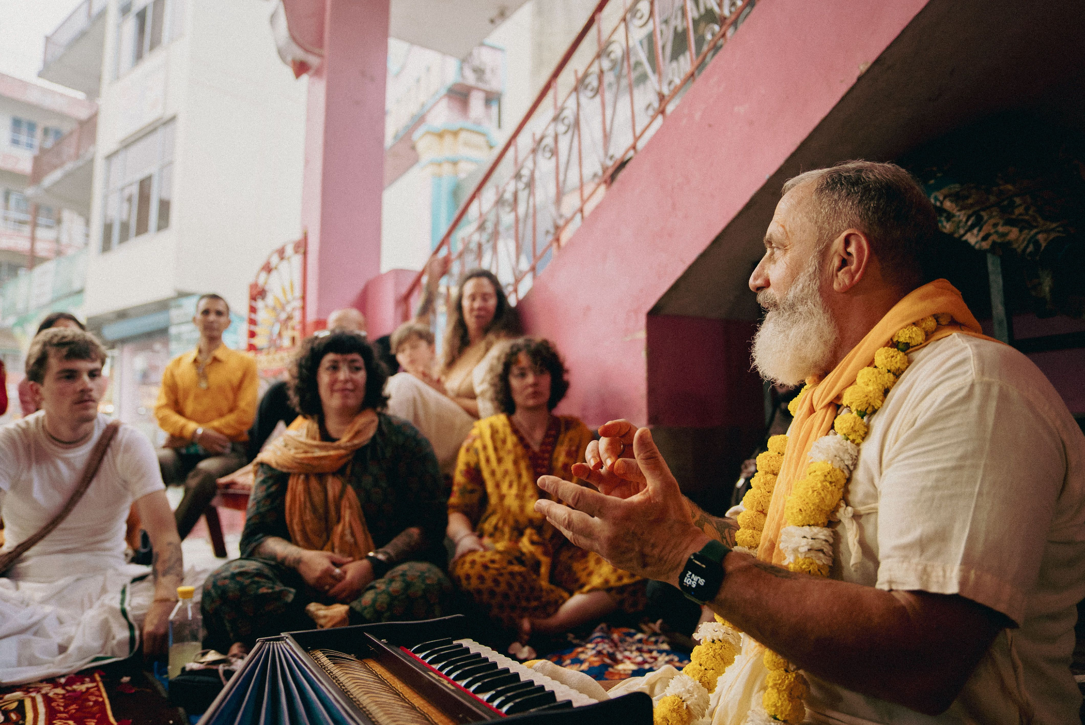 Raghunath Cappo teaching bhakti yoga philosophy and leading kirtan with pilgrims inside a temple in India during a guided spiritual pilgrimage.