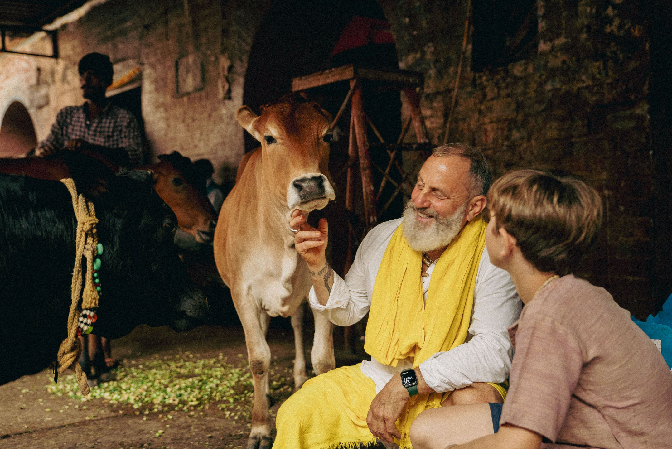 Man with a gray beard and prayer beads holding a small flame during a quiet outdoor ritual at sunrise, symbolizing meditation, devotion, and spiritual practice.
