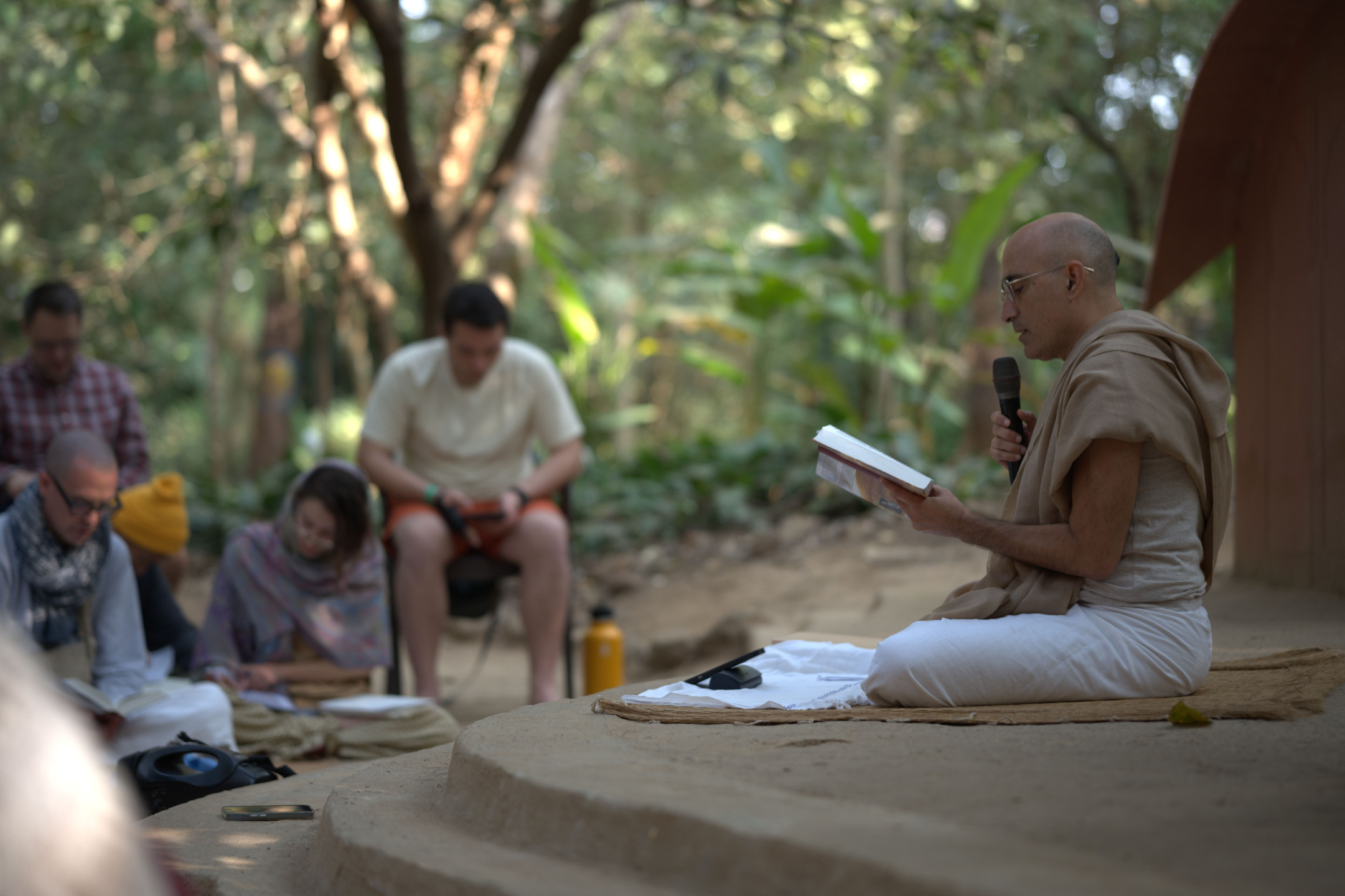 Kaustubha Das teaching yoga philosophy and sacred texts during an outdoor satsang at Govardhan Eco Village in India.
