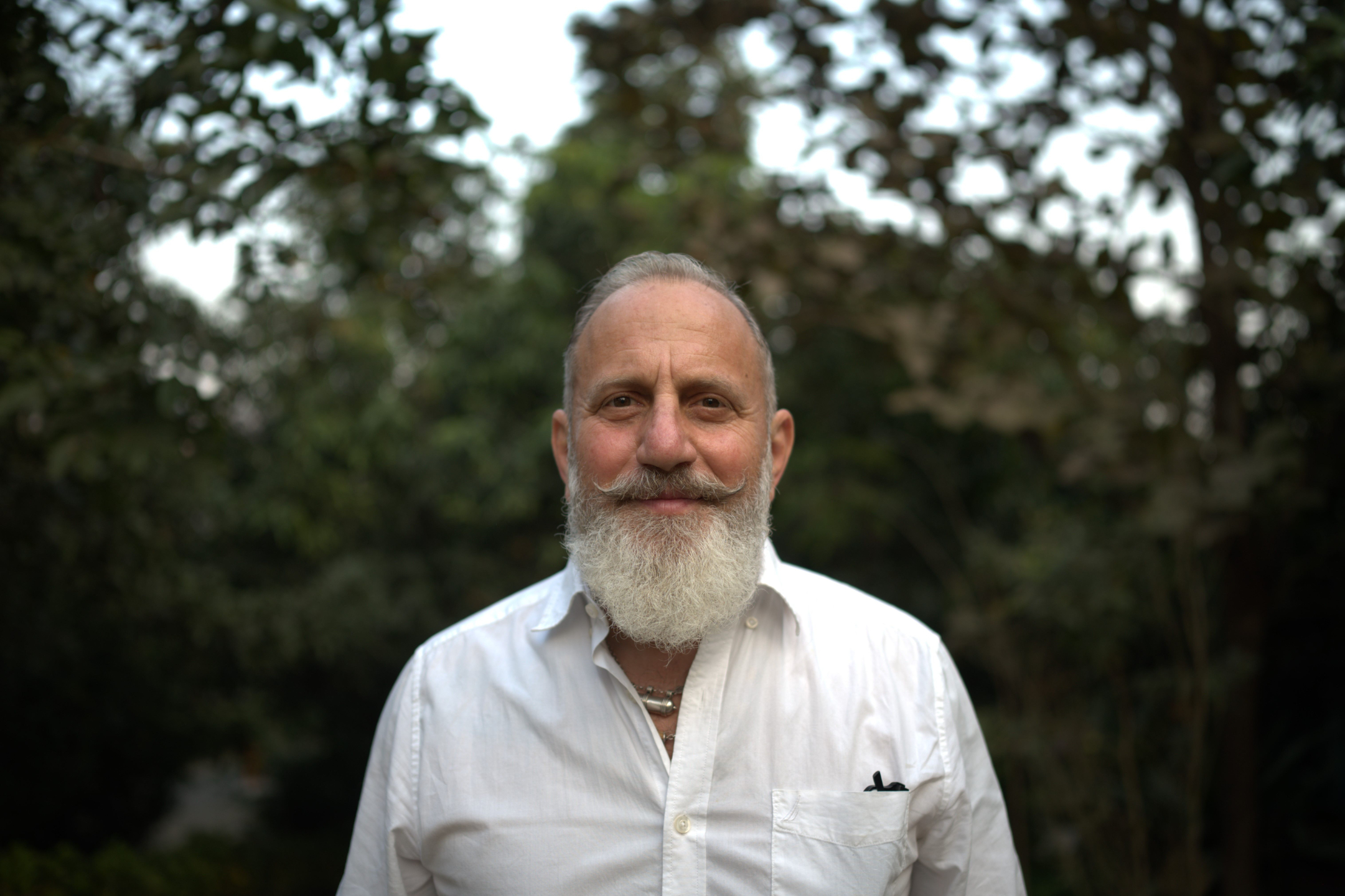Raghunath, lead instructor of a yoga teacher training in India, photographed outdoors in a natural setting.