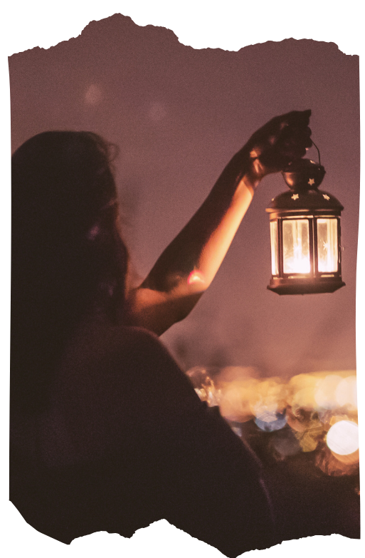 Person holding a lantern in darkness representing the search for meaning during inner change