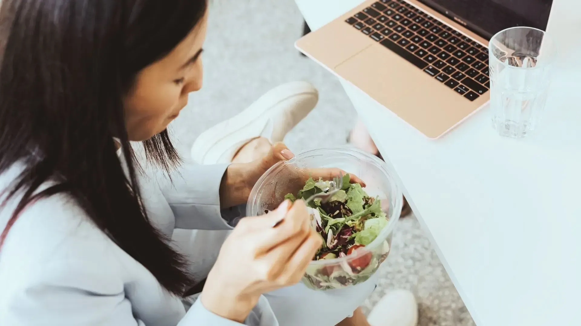 Girl eating salad at desk