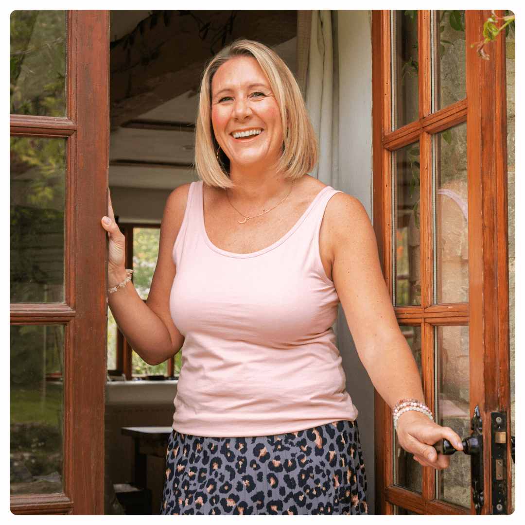 Karen Sutton sitting on a teal couch with yellow and blue cushions, holding a yellow mug. The image has a sunflower-themed border and represents a free guide to easing the grieving journey.