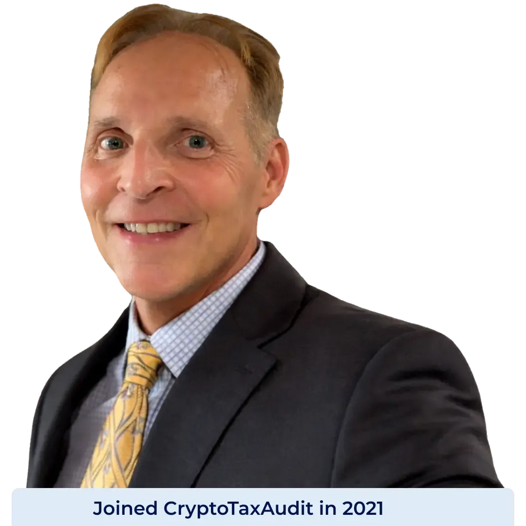 Portrait of Kent Bowen, Director of Client Solutions at CryptoTaxAudit, wearing a dark suit, light blue checkered shirt, and yellow patterned tie, smiling against a dark background. Joined CryptoTaxAudit in 2022.