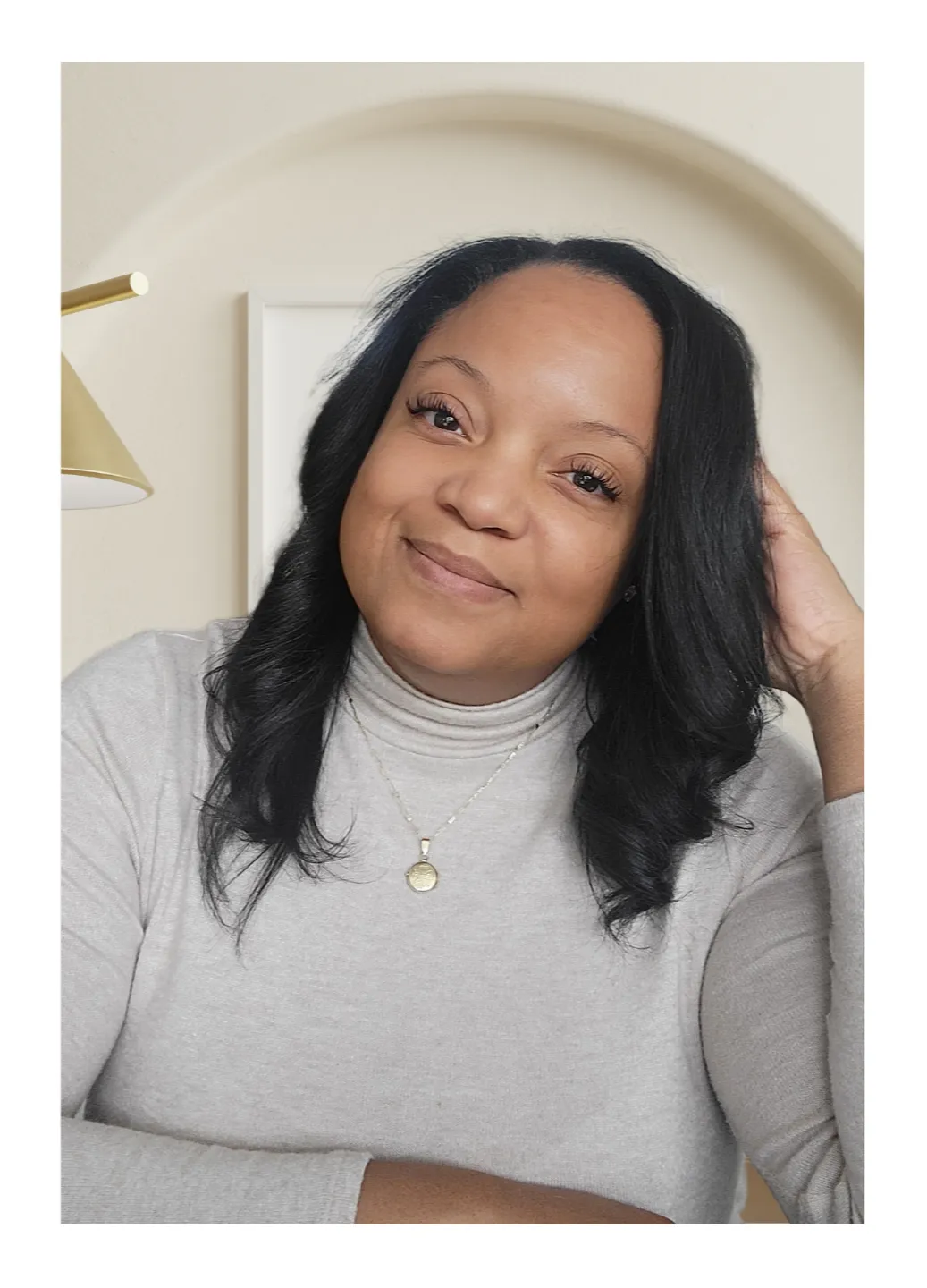 Chiriga Derrick smiling and seated, representing her personal and professional mission to empower entrepreneurs through strategic design and brand alignment.