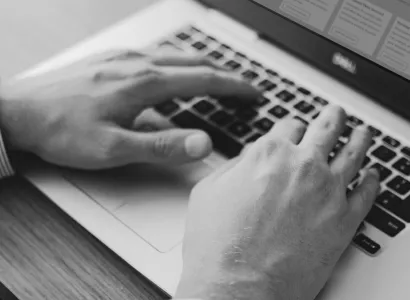 woman sat at a table smiling with her hands together chatting to a friend