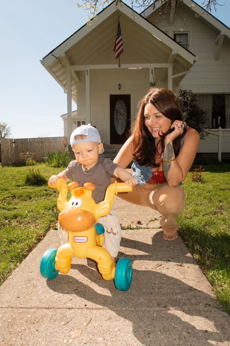 Annie sitting in a sofa wearing a dark blue dress and carrying a MacBook in hand