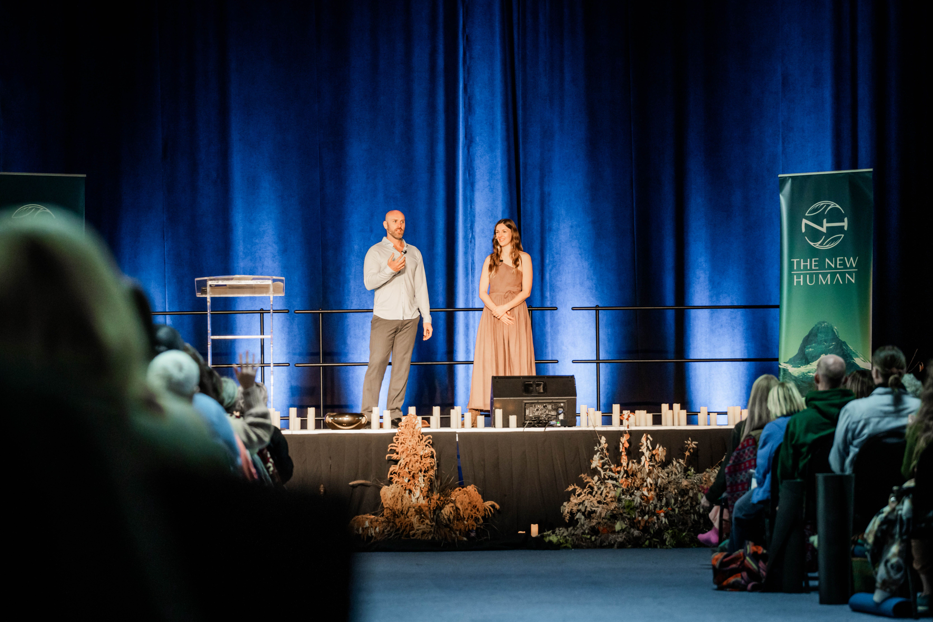 Mike and Courtney speaking on stage to a full room
