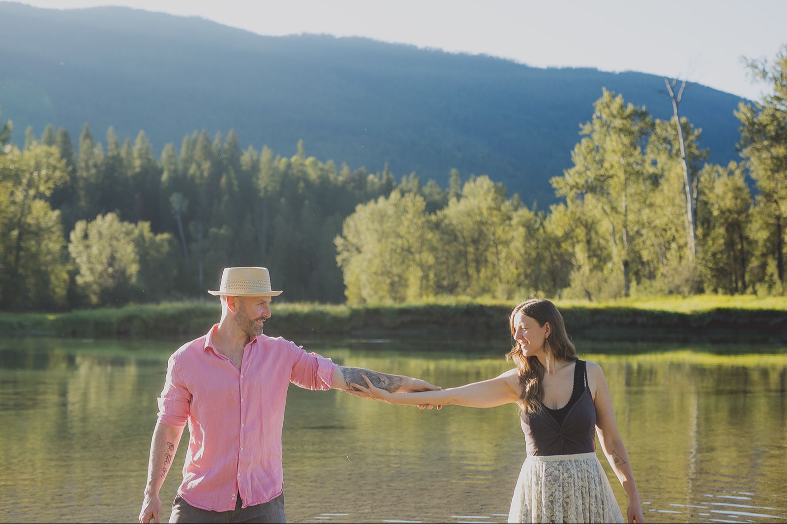 Mike Elliott and Courtney Wren holding hands by a mountain lake