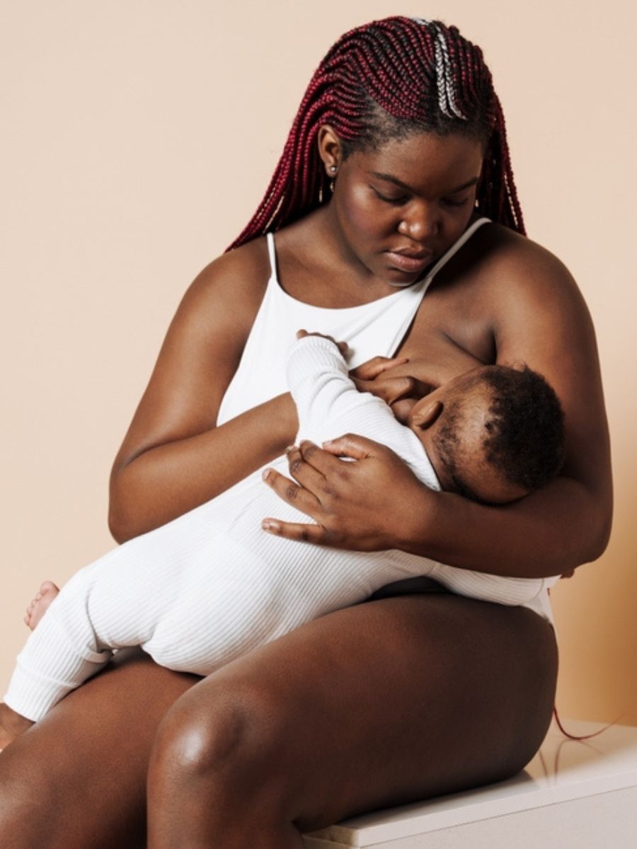 Mother joyfully holding her baby, showcasing a successful pain-free latch after the Reflexive™ Latching Masterclass.