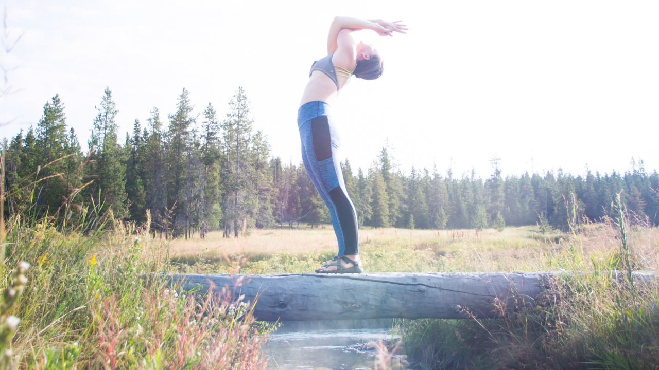 Kendall standing on log in backbend 
