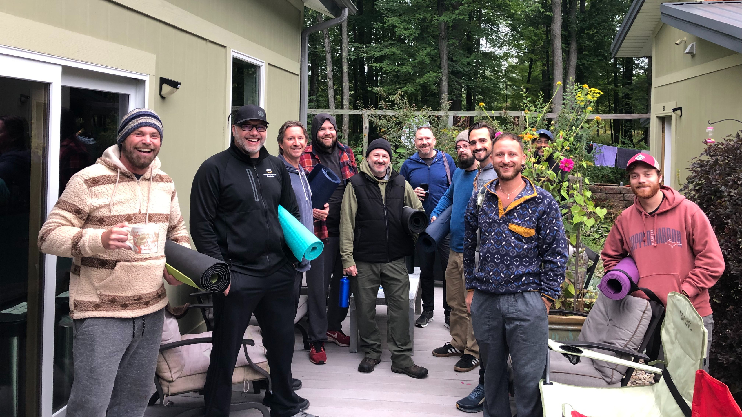 A man relaxing on a paddleboard on a river surrounded by forest, representing the outdoor adventure and rest of men's therapy retreats