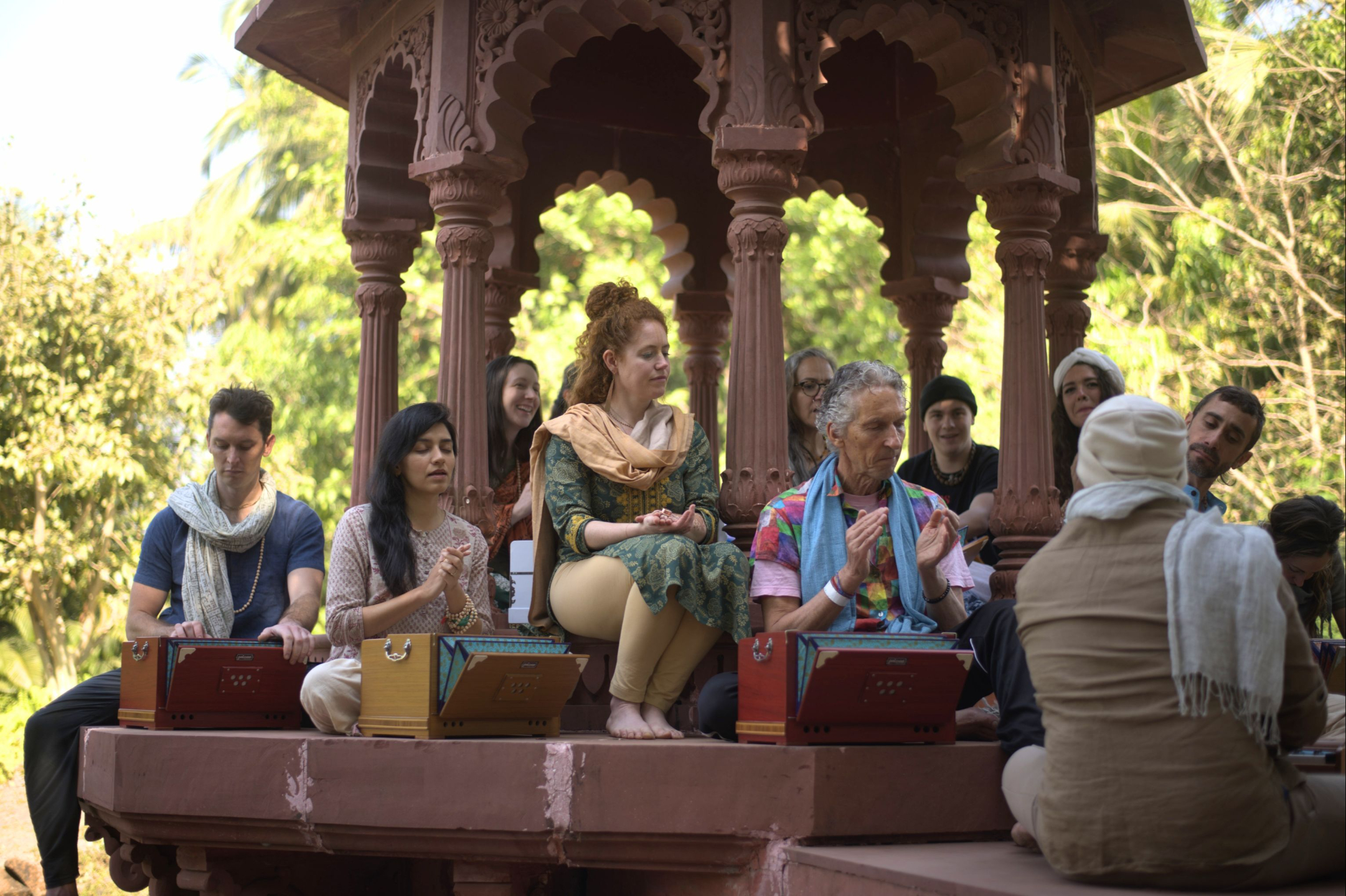 Students practicing harmonium and devotional kirtan during Kirtan School training in India at a Bhakti retreat setting.