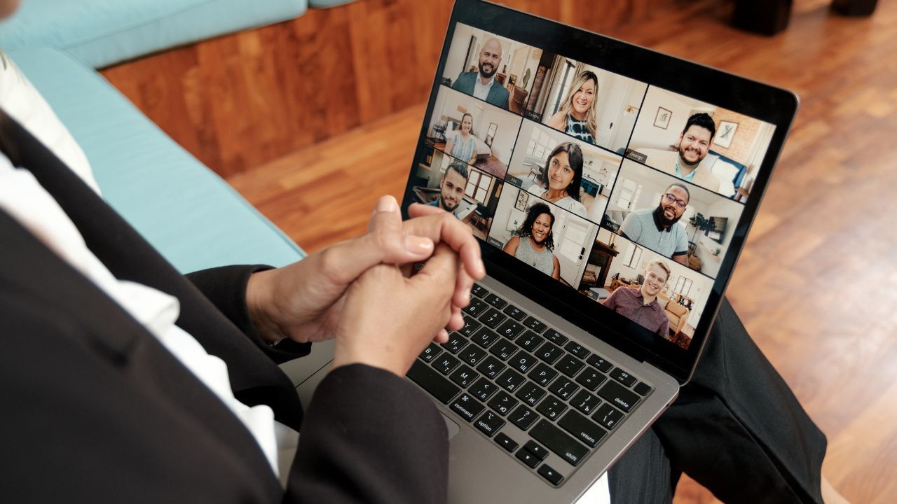 Diverse group of ministry coaches participating in a live group coaching session on Zoom, laughing and engaging with each other in a warm, professional setting