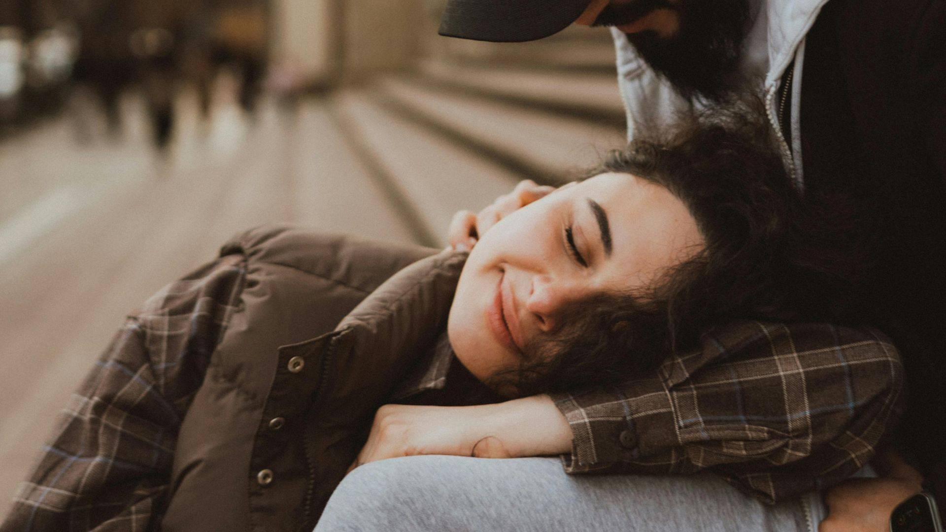 Tendresse. Femme amoureuse posant sa tête sur les genoux de son partenaire