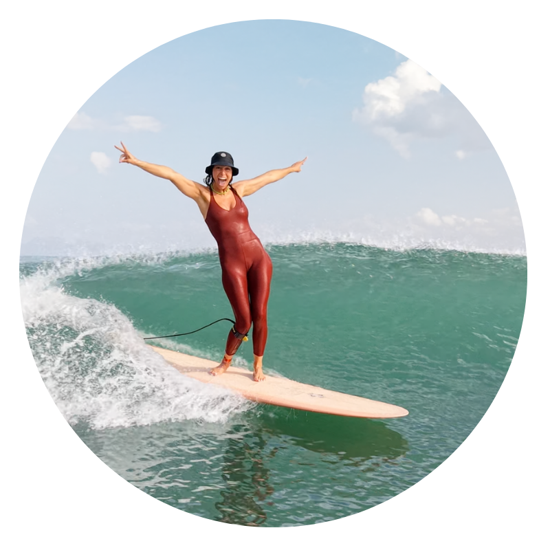 surfer girl smiling in the water after taking beautiful and best waves of the day, best surf retreat bali and lombok, surf coaching beginners and intermediates