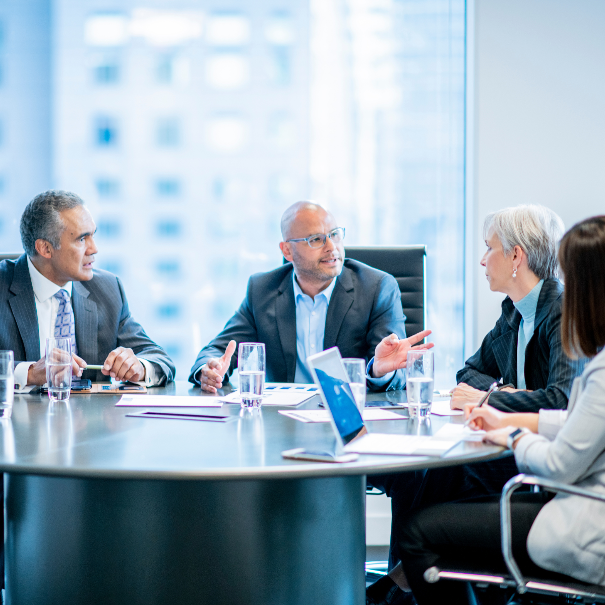 Group of professionals in discussion around a boardroom table