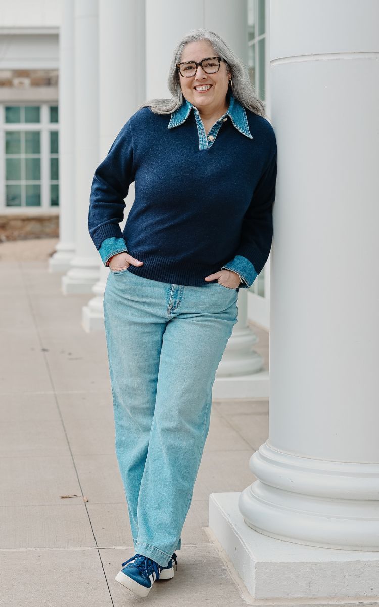 Danielle leaning against pillar smiling at camera