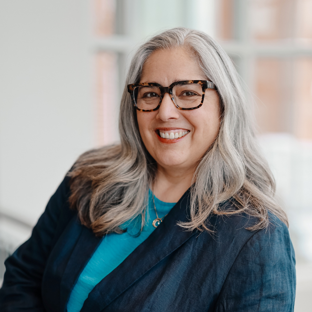 Danielle in teal shirt looking directly at camera smiling