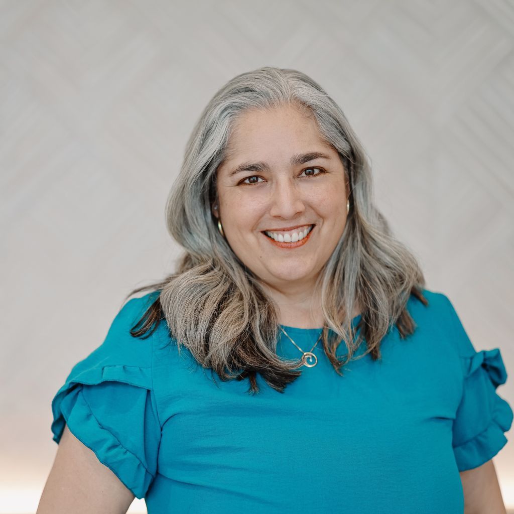 Danielle in teal shirt looking directly at camera smiling