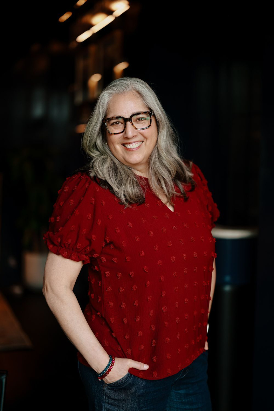 Danielle in red facing camera smiling