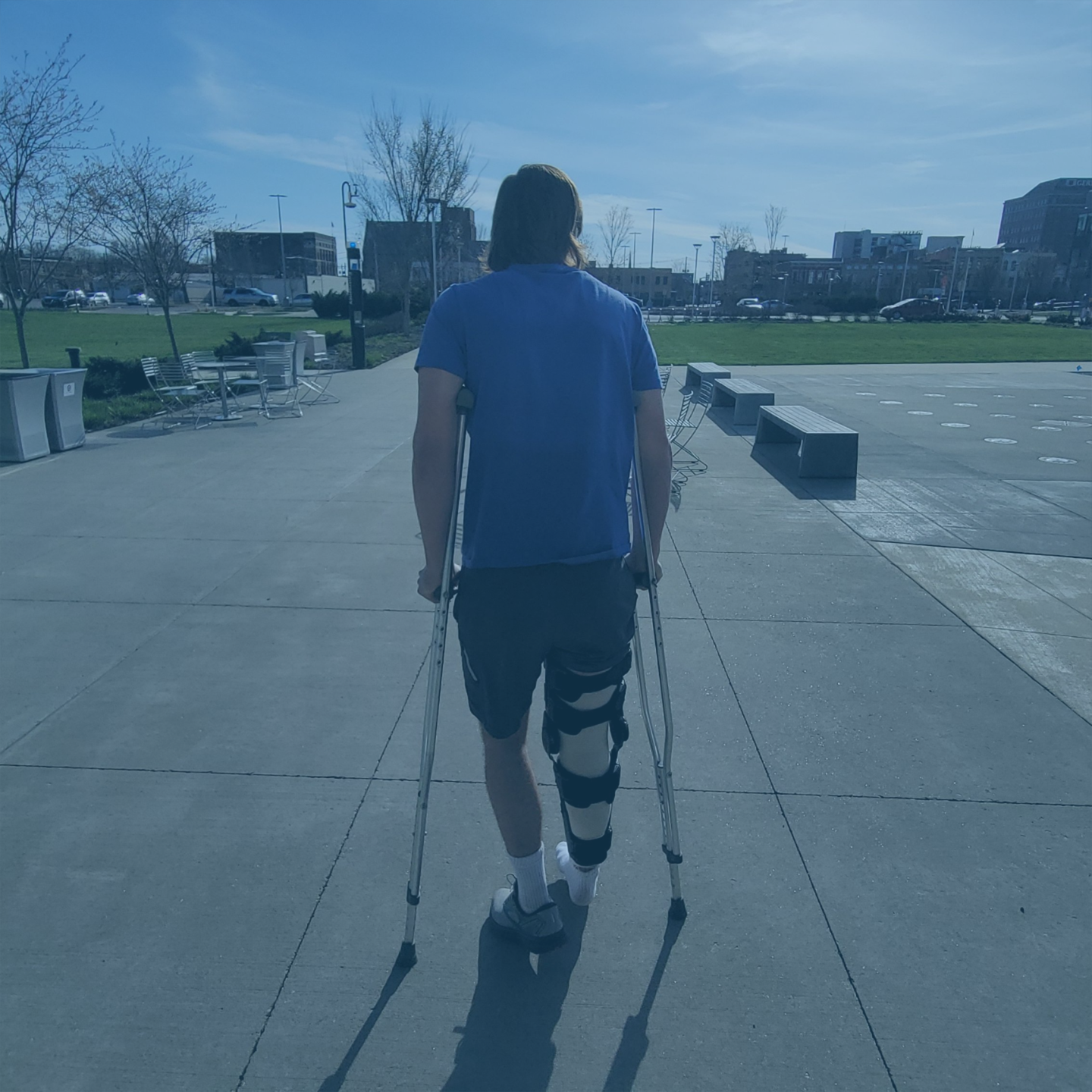 Athlete walking on crutches with knee brace after ACL surgery during early rehabilitation phase