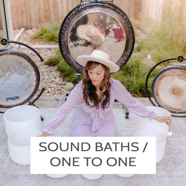 A woman in pink giving a Sound Bath with Crystal Bowls