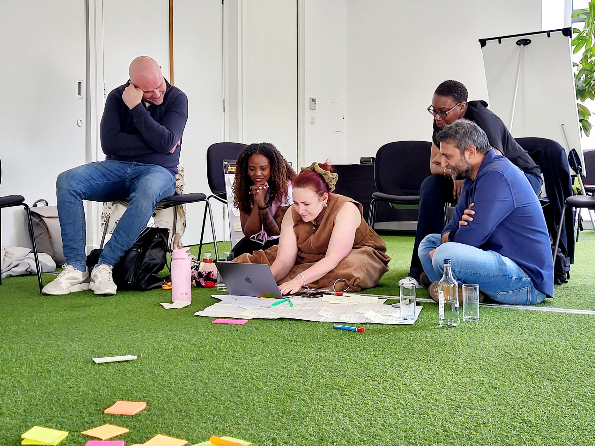 A Futures programme project team working together on the floor with sticky notes and a laptop
