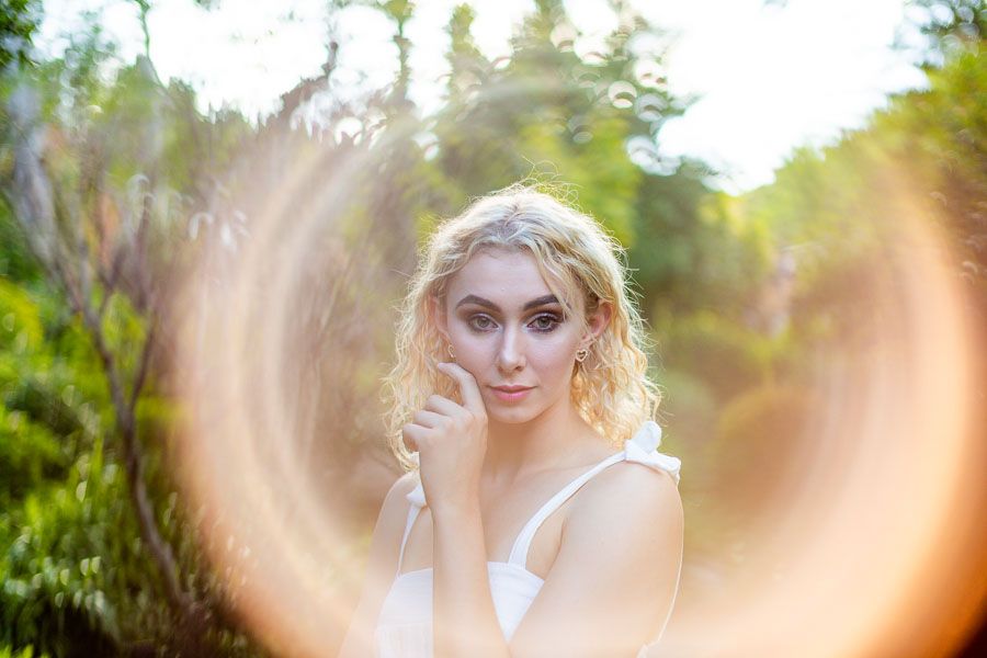A trick photograph of a woman's face glowing with colourful glow in the dark neon paint under UV black light. Learn how to do black light photography with this tutorial.