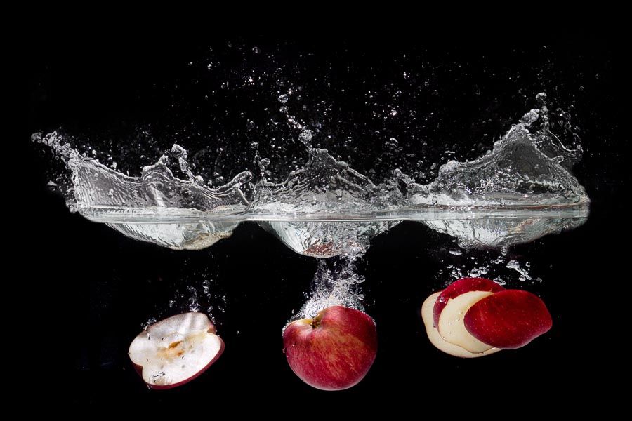 A photograph of a sky full of fireworks exploding over the city of Brisbane, reflected in the river, showing how to take fireworks photography long exposures.