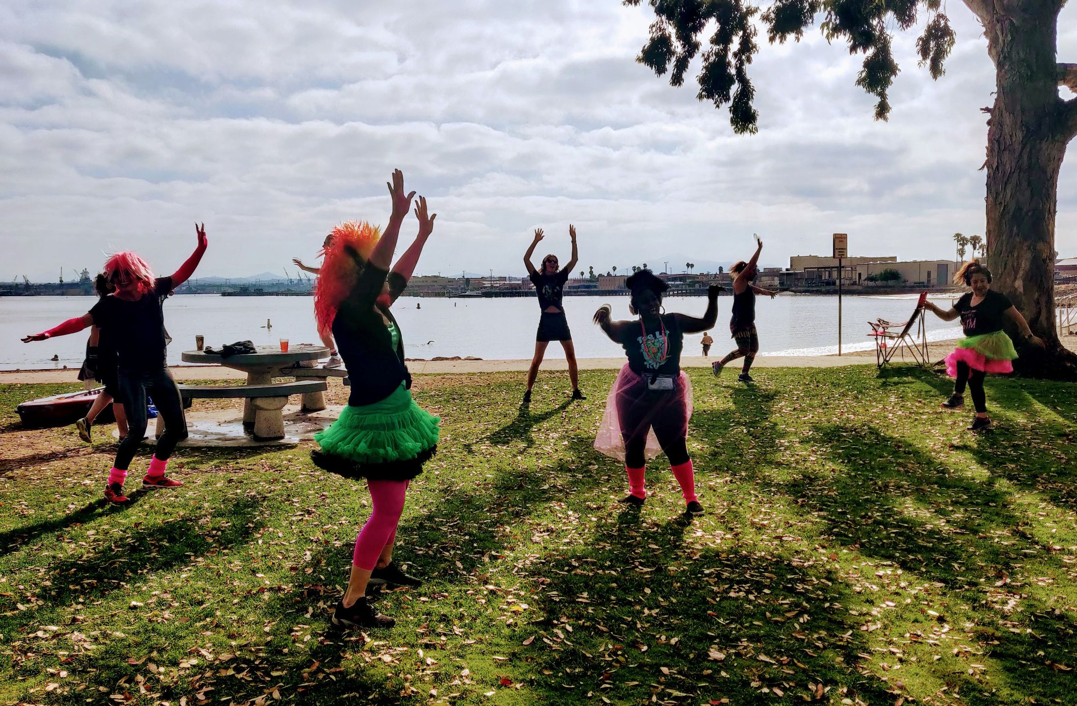 people in 80s costumes dancing by the water