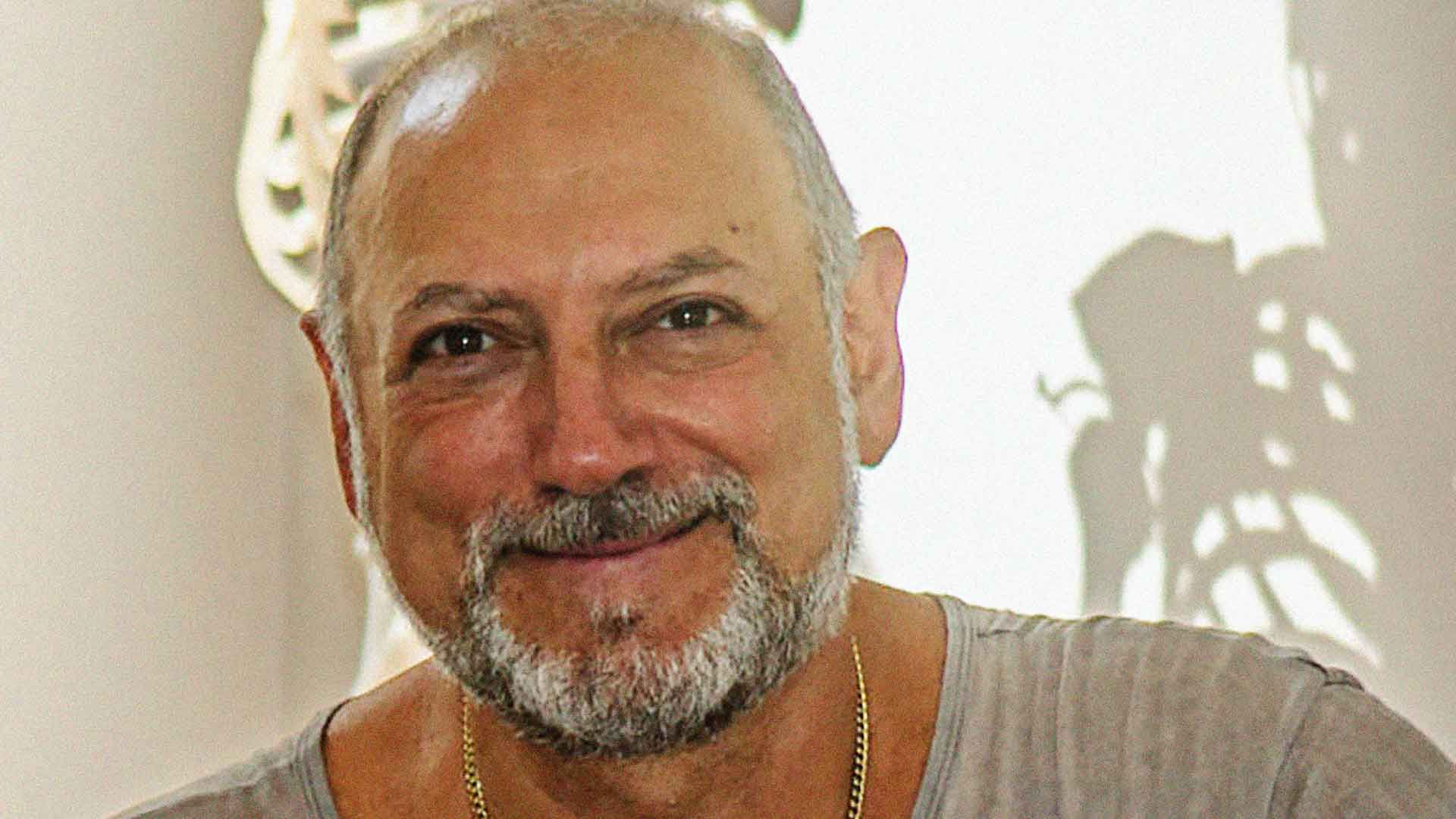 Leslie smiling with the shadow of a skeleton behind him.