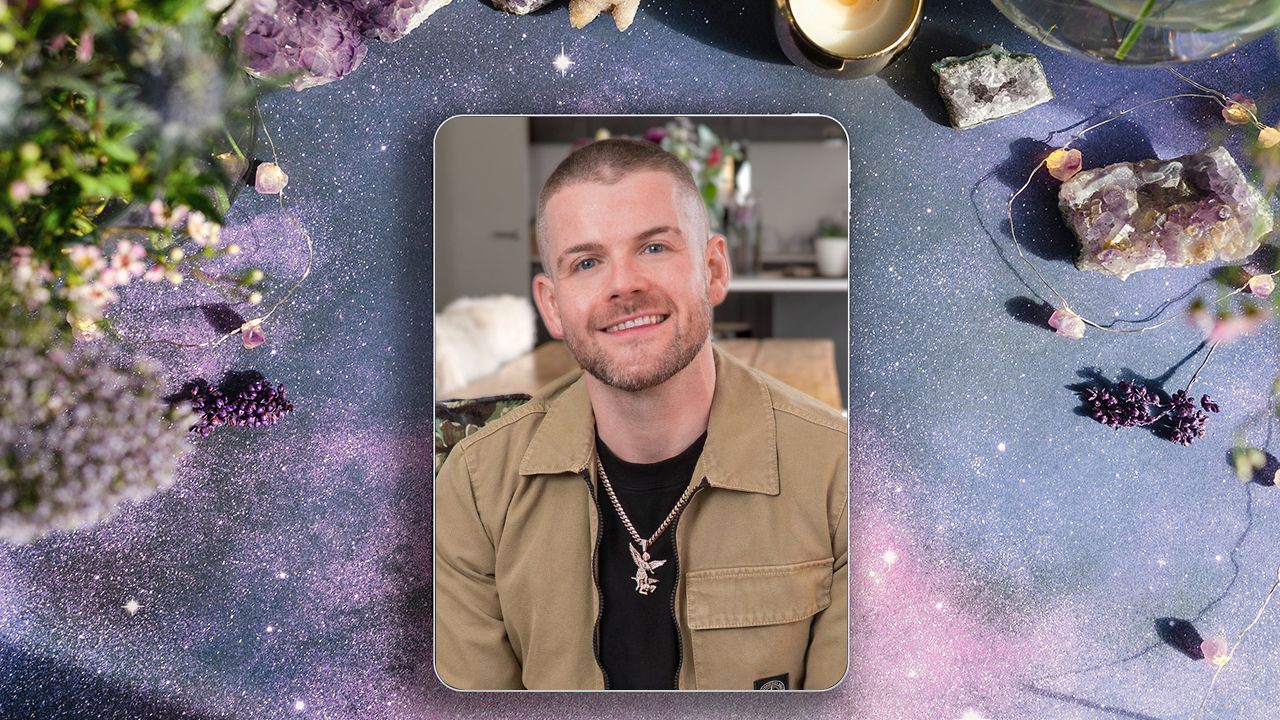 A photograph of Kyle Gray sitting on a couch smiling