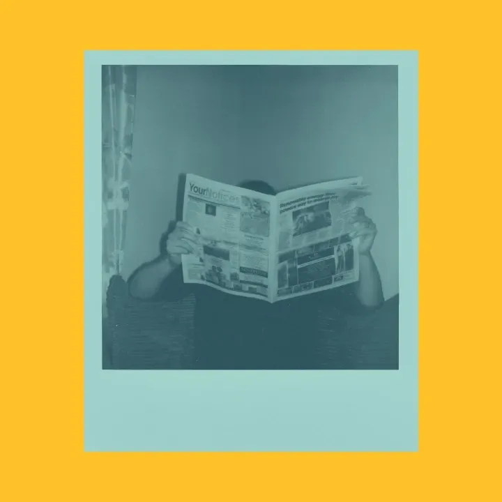 polaroid of a man reading a newspaper