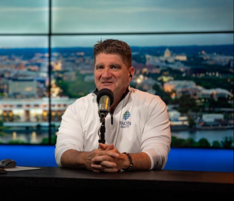 Todd sitting at desk speaking into microphone.