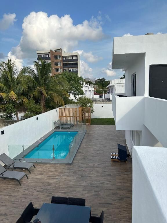 Birds eye view of private pool from balcony.  Sun chairs visible on each side of the pool