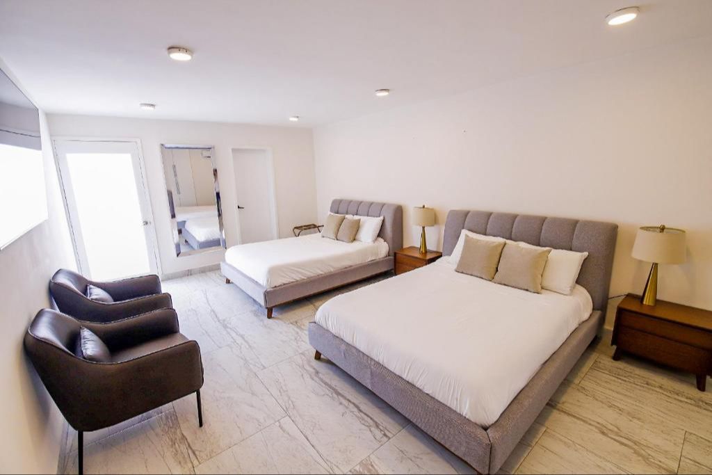 Large bedroom with two queen sized beds and plenty of space.  There is a window in the bedrooms, as well as a door leading out to the pool.