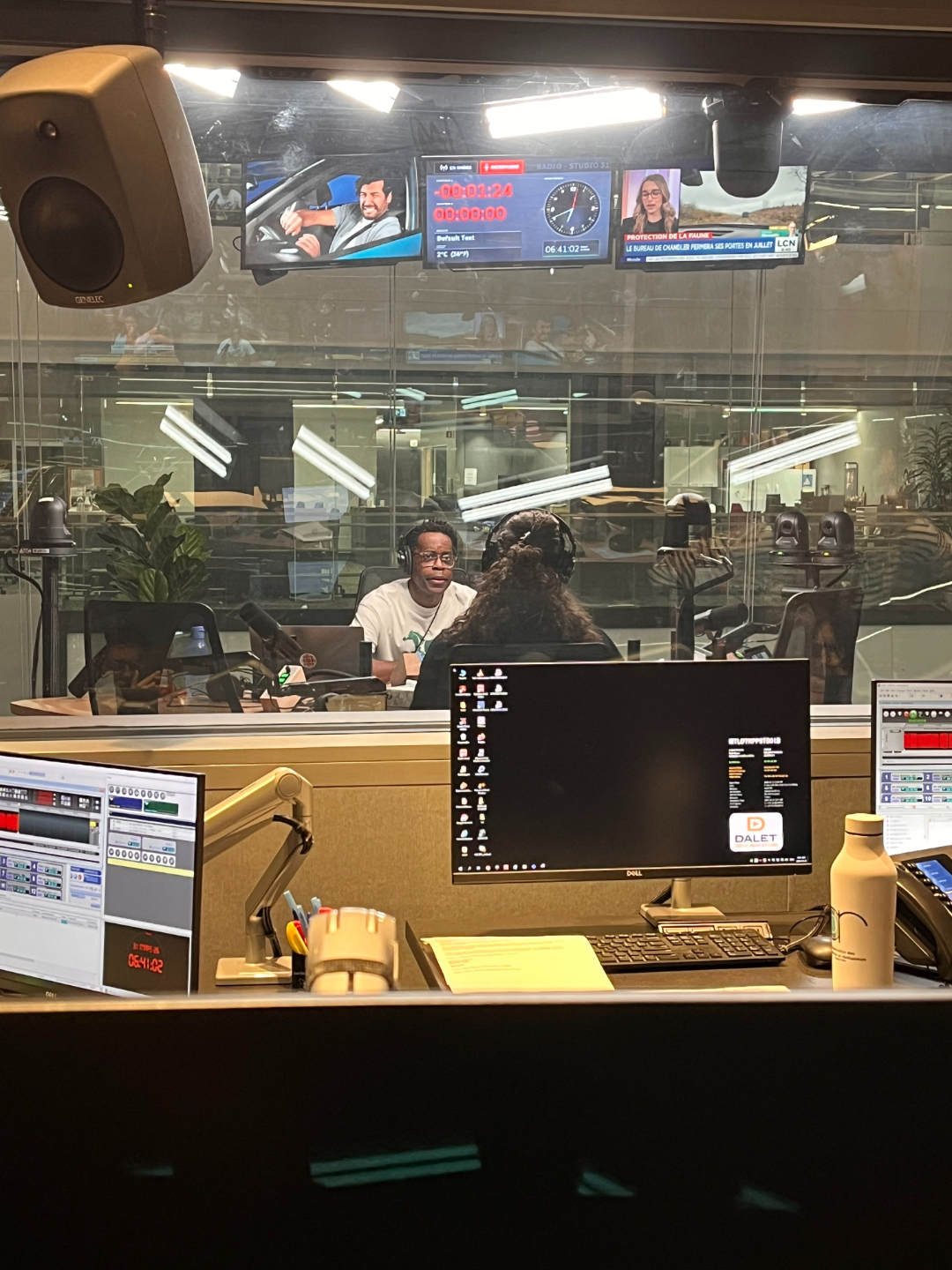 View through the control room glass of Ren&eacute;e Yoxon and Sean Henry recording a gender-affirming voice training segment at CBC Montreal