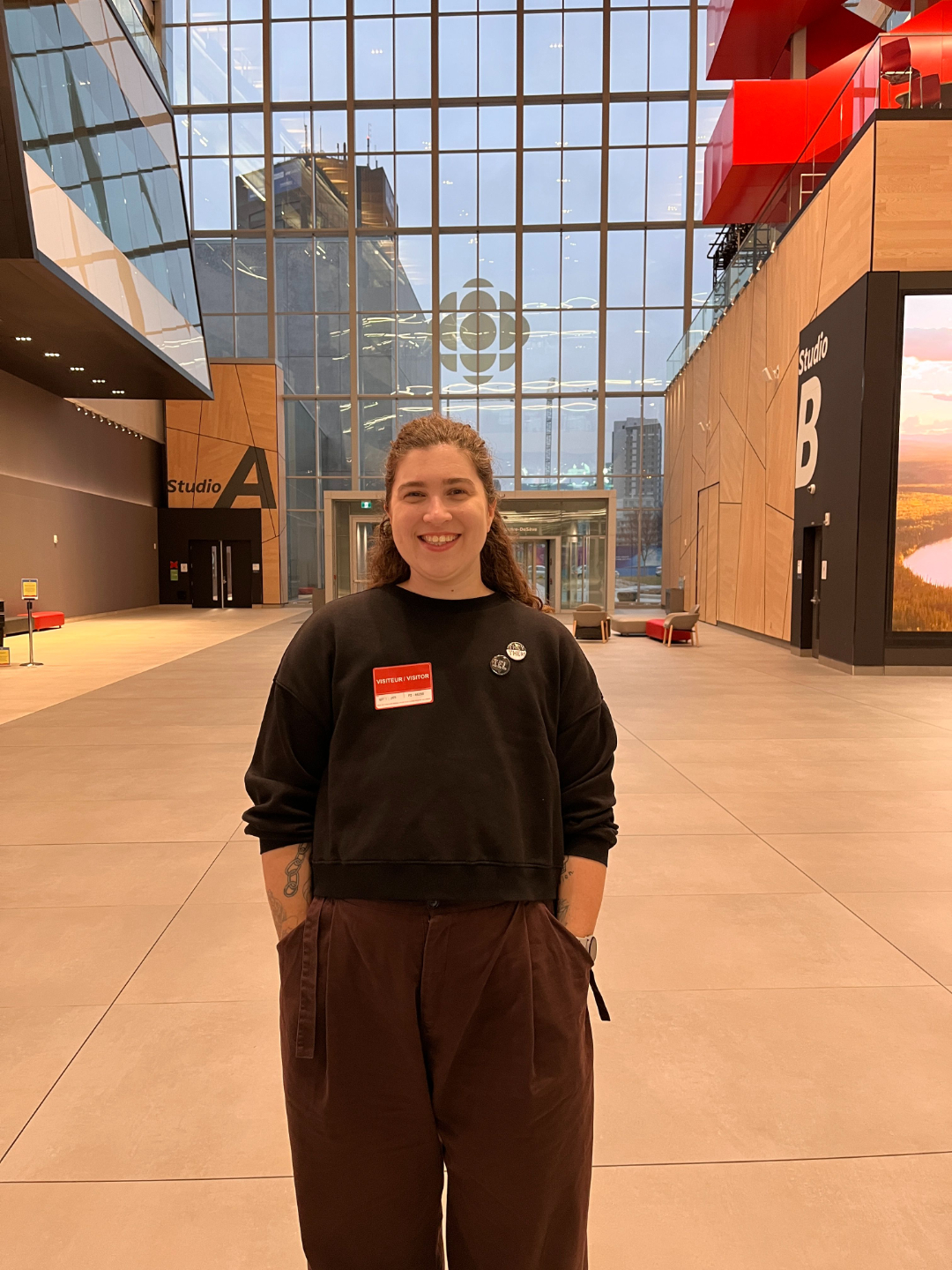 Ren&eacute;e Yoxon smiling in the CBC Montreal atrium, with Studio A and Studio B visible in the background