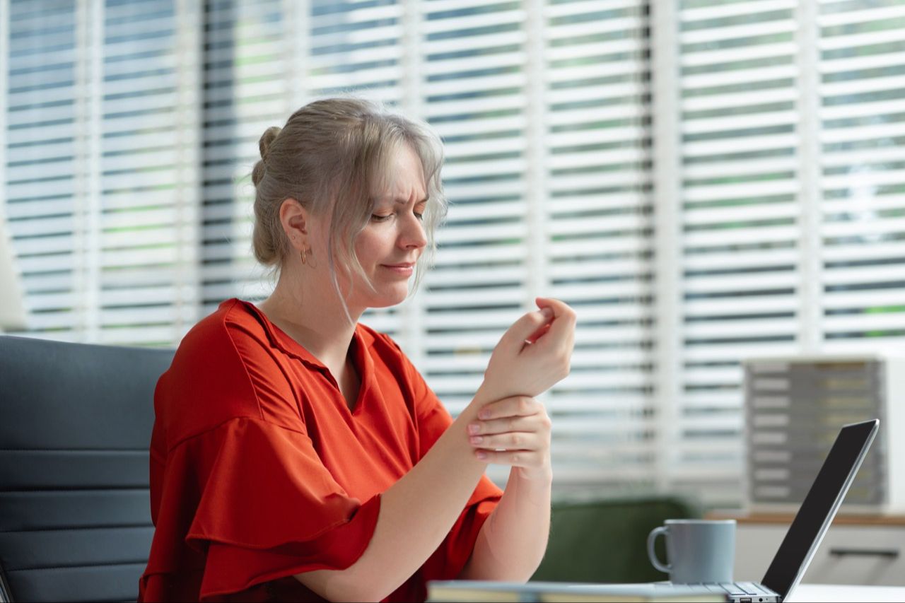 Office worker with wrist pain and numbness, a common symptom of Thoracic Outlet Syndrome