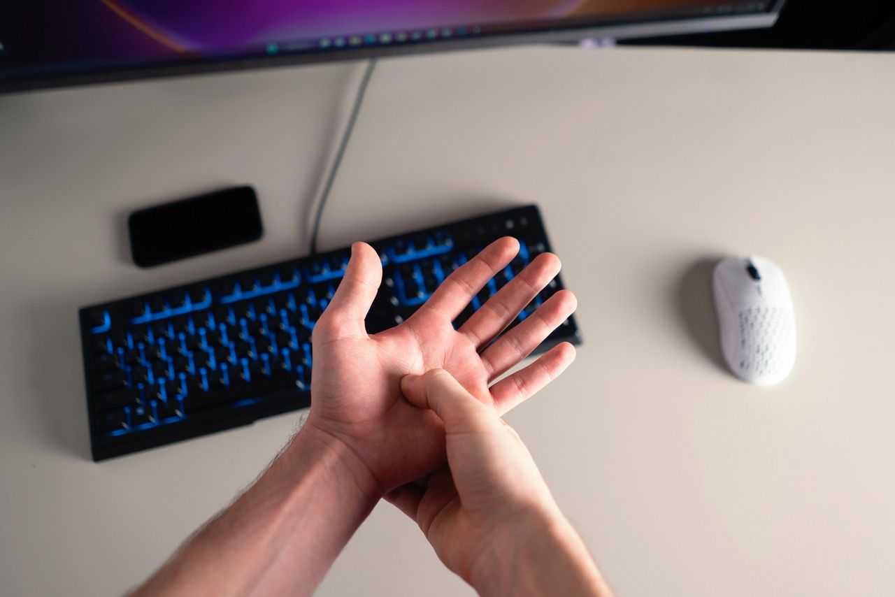 Hands feeling "dead" and numb at a computer, showing the reality of the TOS "Rest Trap" cycle