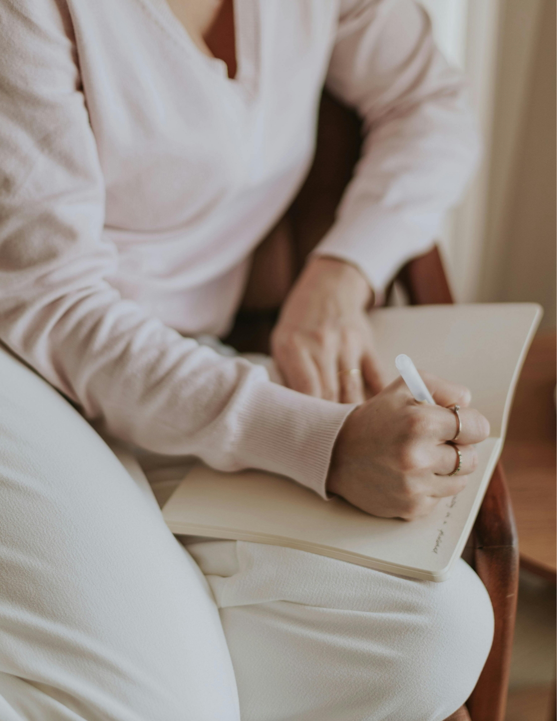 person with notebook and pen taking notes