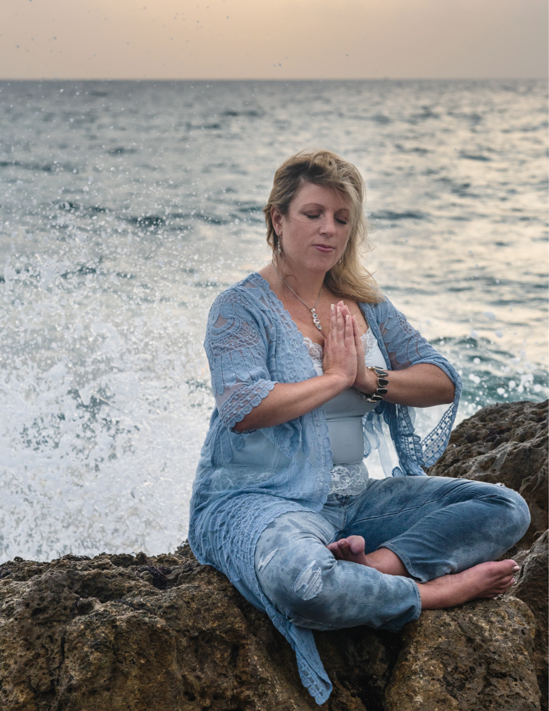 person facing sunrise hands in yoga position fingers touching