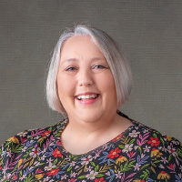 Smiling mature woman with smart grey bobbed hair and a colourful top